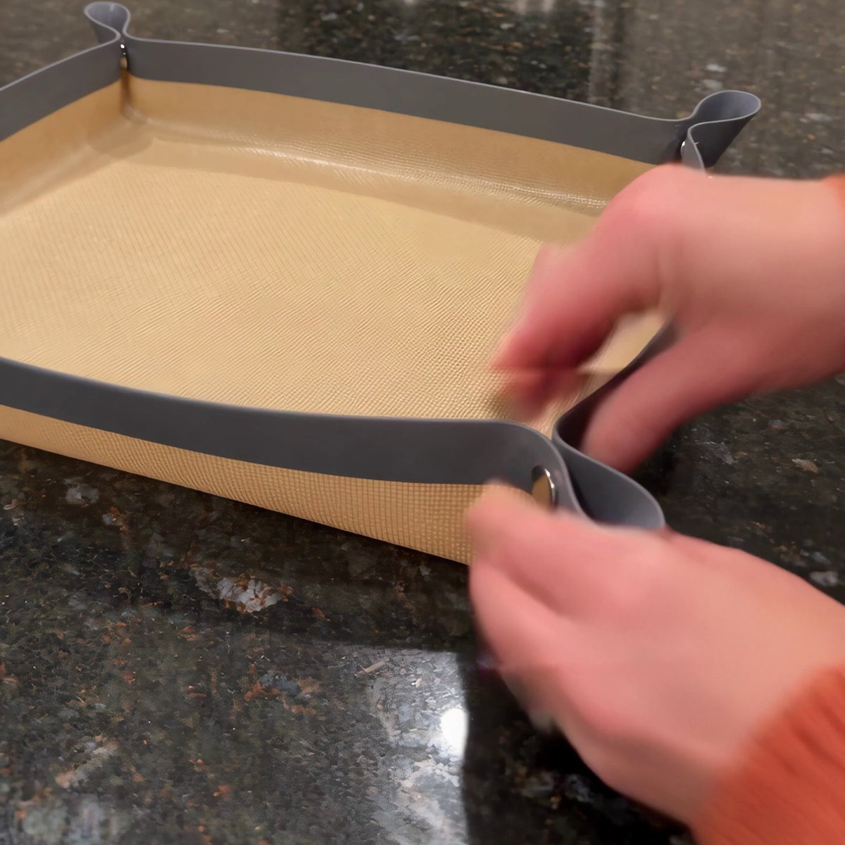 Hands snapping a corner of the Snap Tray